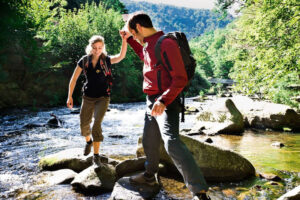 Wanderer beim Überqueren eines Flusses im Harz